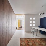 Raúl Sanchez Architects divides Barcelona apartment with 21-metre-long wooden wall
