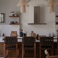 Kitchen interior with wood cabinets, white splashback and wood kitchen island