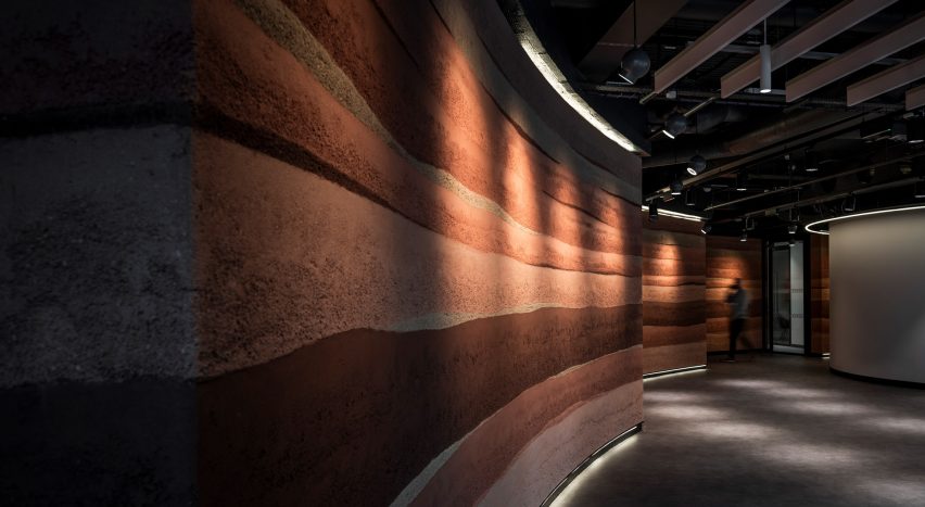 Claywork rammed earth wall finish in a dark room
