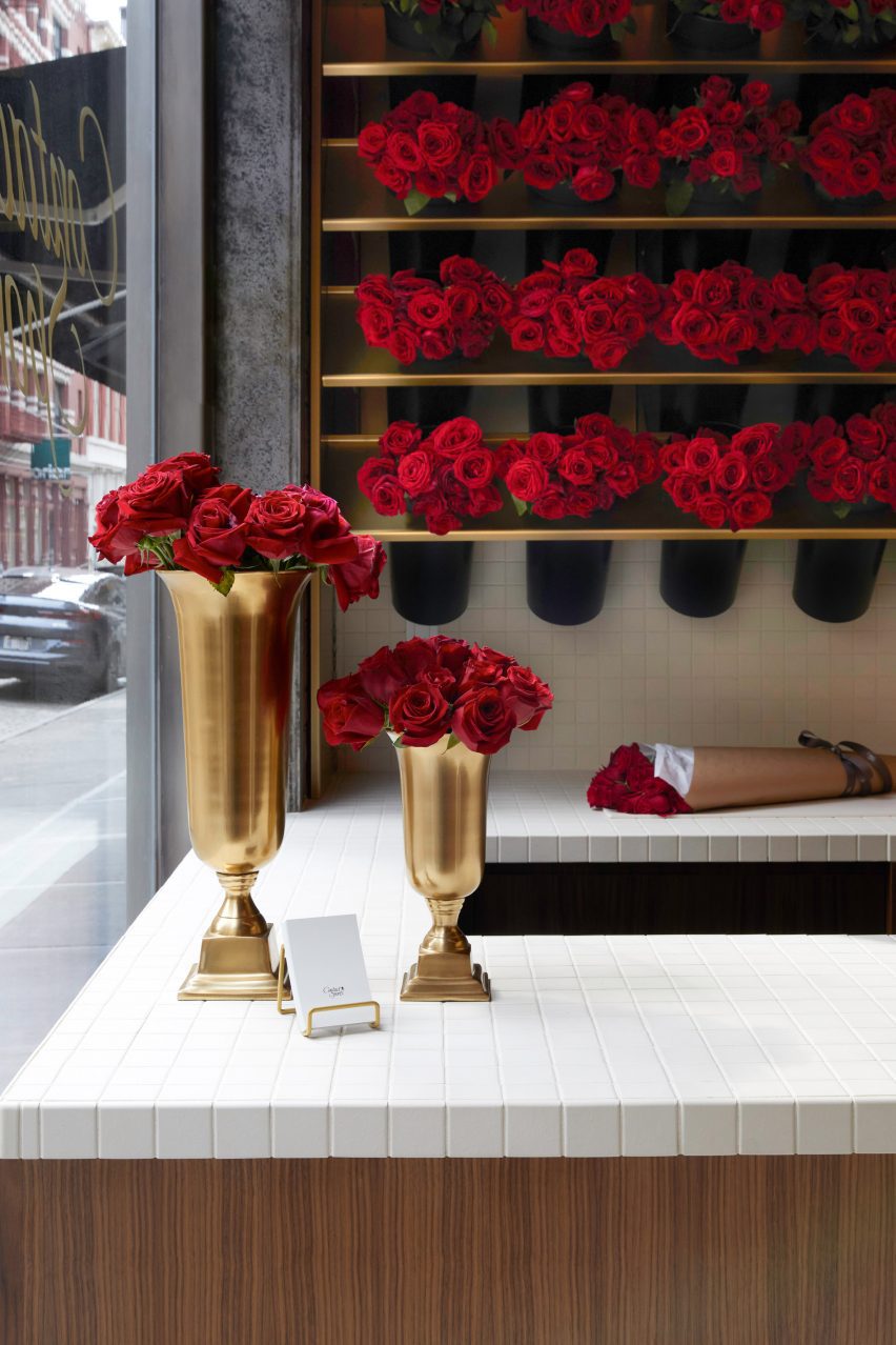 گل رز قرمز ساقه بلند که در گلدان های غنیمت مانند نمایش داده می شود