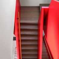 Staircase with dark wood steps and red balustrades