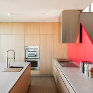 Kitchen with red staircase and wood kitchen units