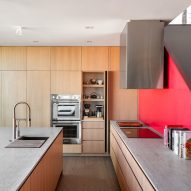 Kitchen with red staircase and wood kitchen units