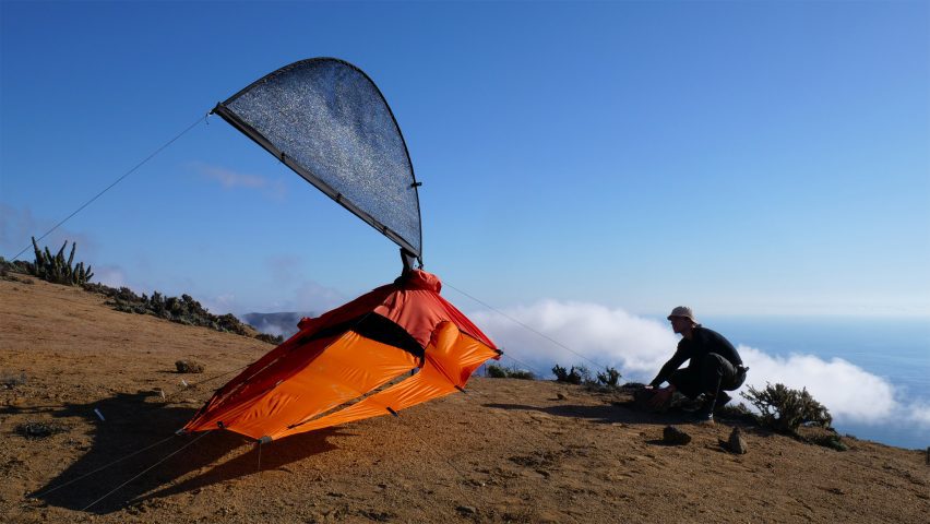 Foto de Pavel Hedström instalando su chaqueta Fog-X como una antena de malla que atrapa la niebla en un entorno exterior brillante con algunas nubes bajas en el fondo