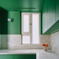 Green kitchen interior of Girona Street apartment in Barcelona, designed by Raúl Sanchez Architects