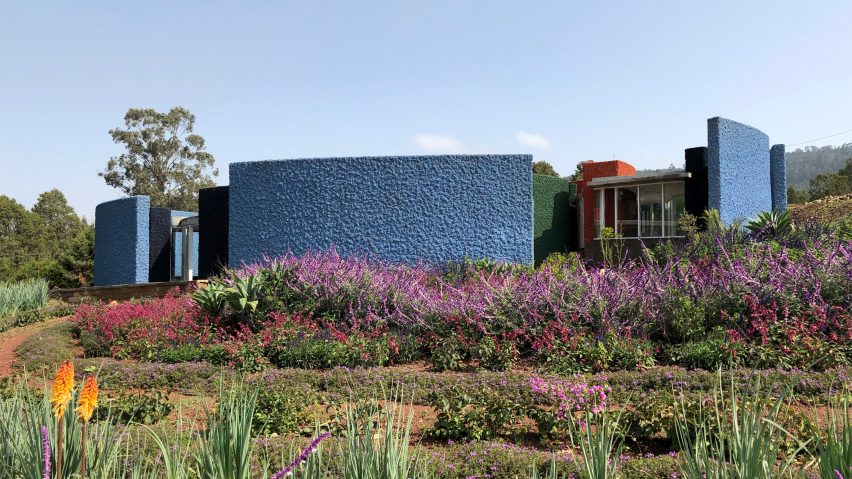 Single-storey guest house with blue exterior walls on a planted landscape at the Meles Zenawi Memorial Park by Studio Other Spaces