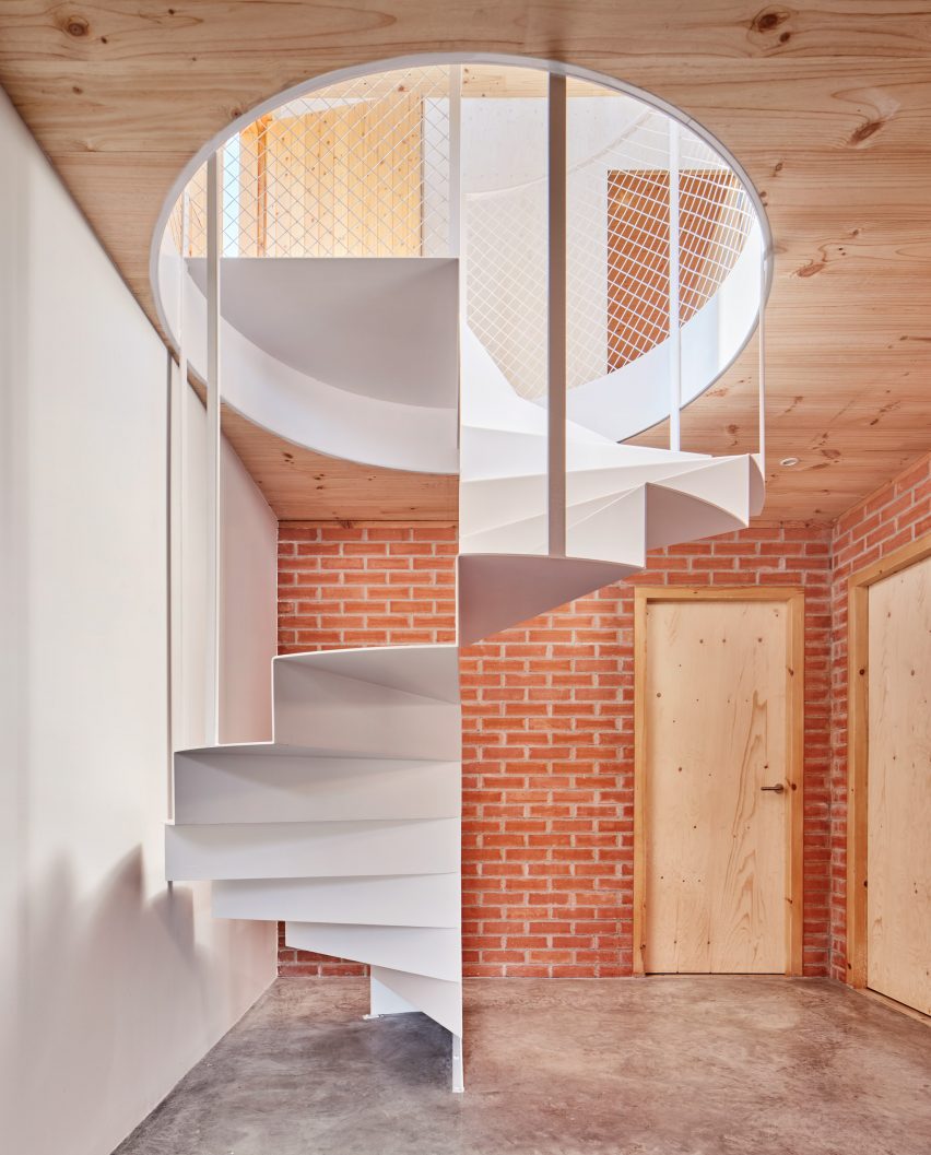 Escalera de caracol en casa española por Agora Arquitectura