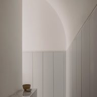 A white room with an arched ceiling and built-in wall cupboards
