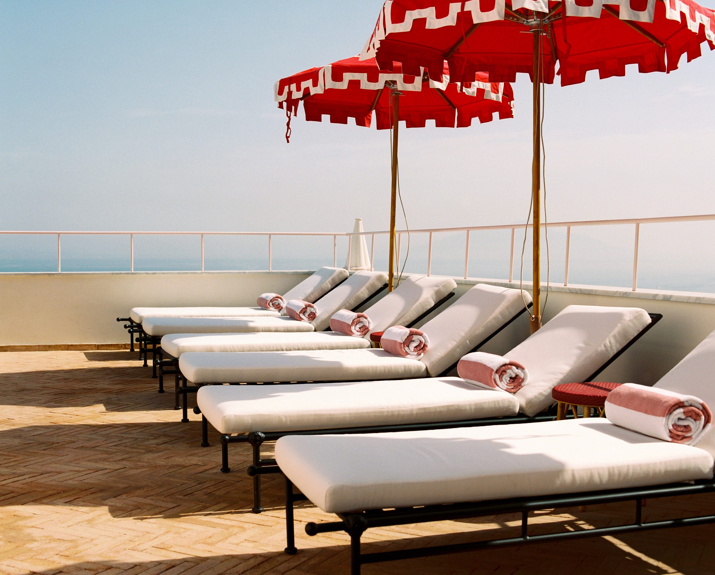 Sun loungers and red parasols
