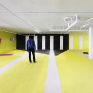 Large open venue space with a white, yellow and black graphic design on the walls and floor