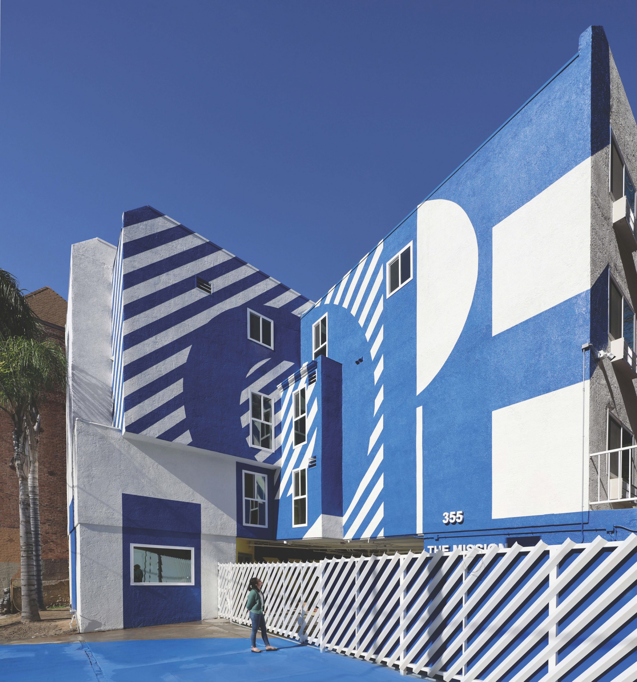 Exterior of the The Alvarado homeless shelter in LA with a graphic blue and white-painted facade