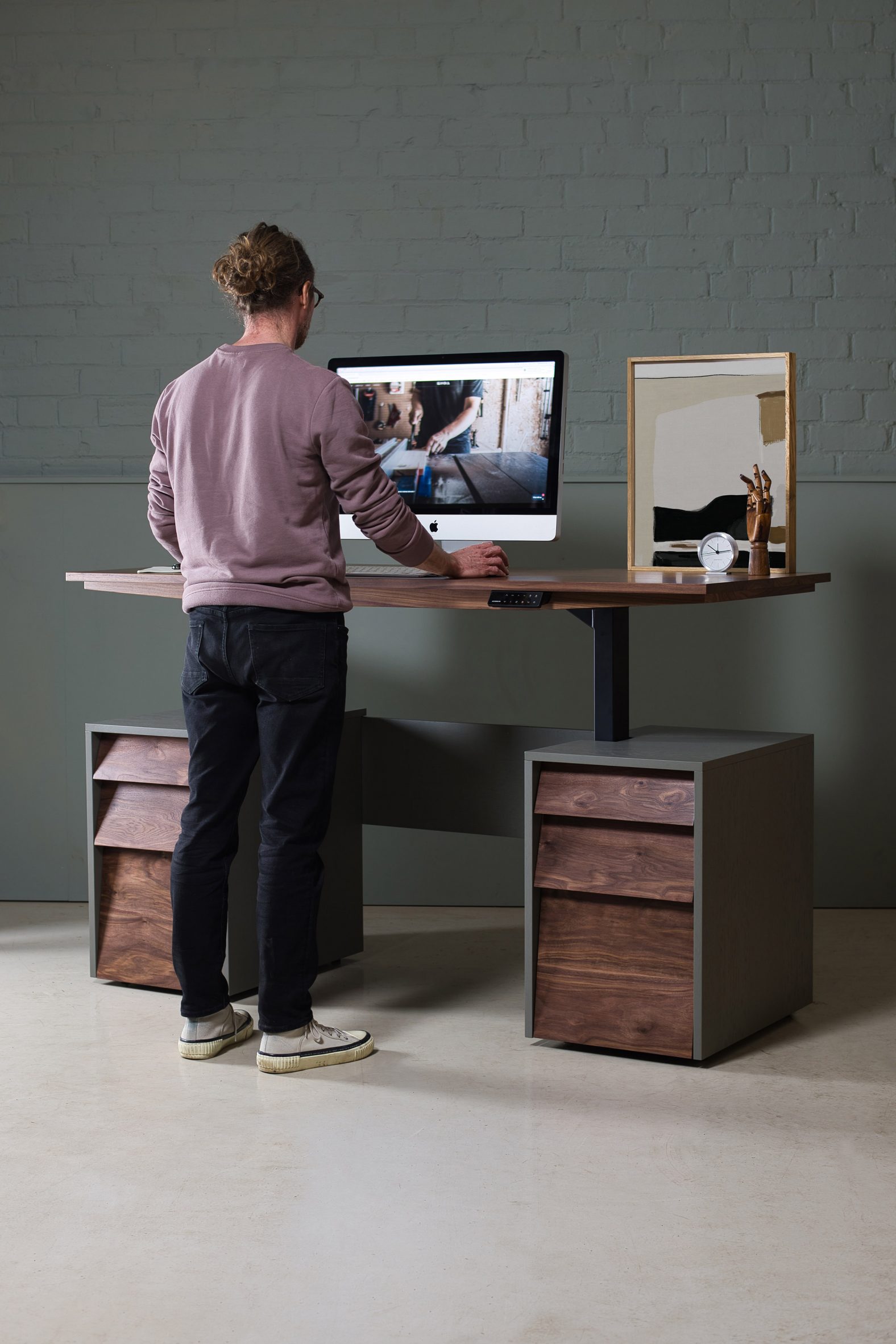 Photo of a person using a wooden height-adjustable desk by KODA