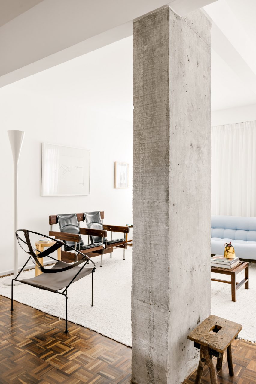 Exposed concrete column with chairs in the background