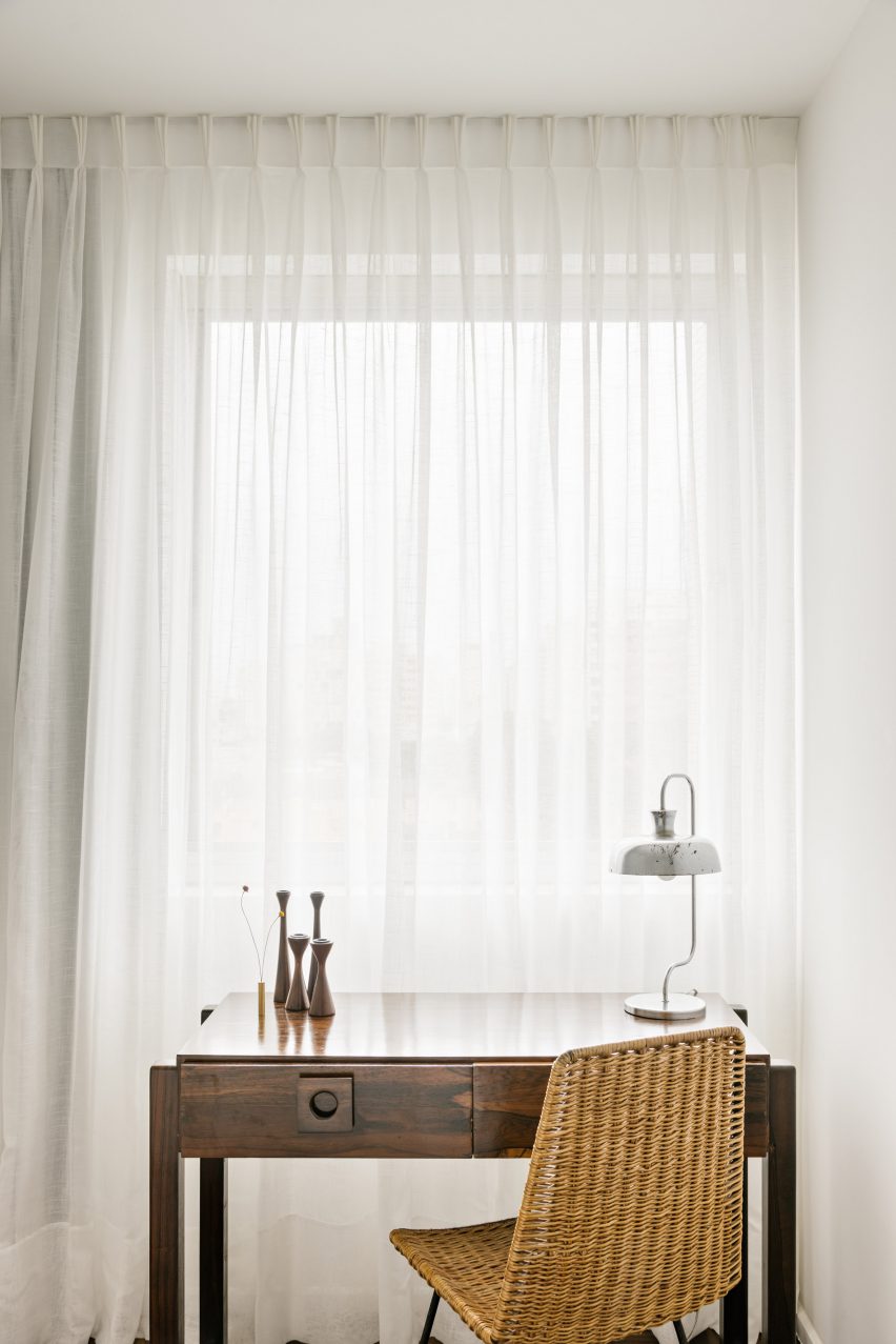 Small wooden desk in front of translucent curtain