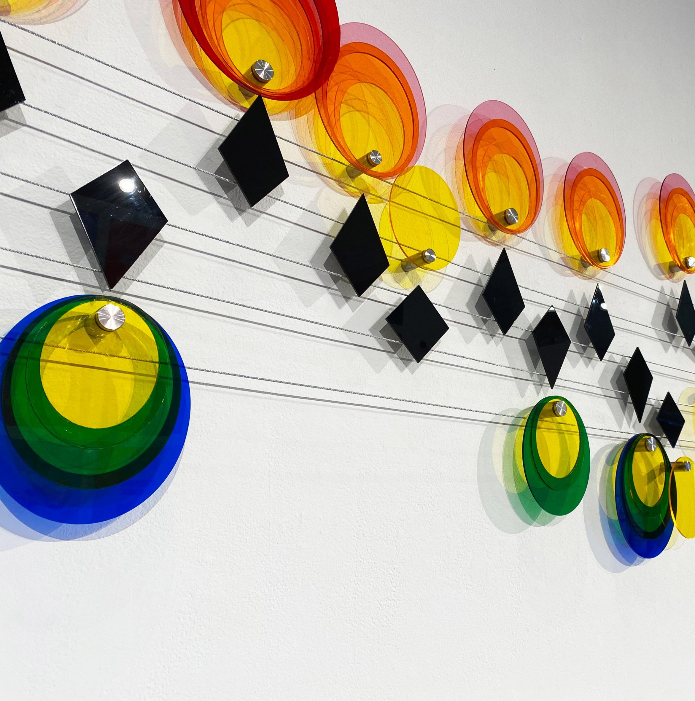 Closeup of colourful plastic circles arranged along a wire