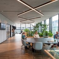 Interior office space with wood flooring, grey walls and large tables