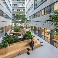 Atrium space at Matrix One by MVRDV with wooden planters and bench seating
