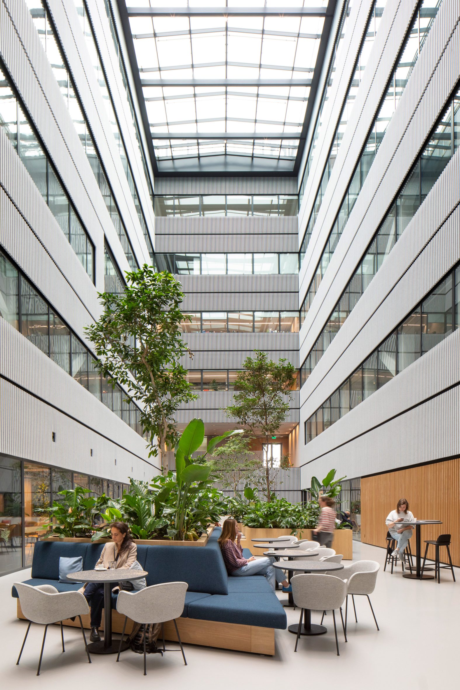 Six-storey atrium with wooden planters and bench seating
