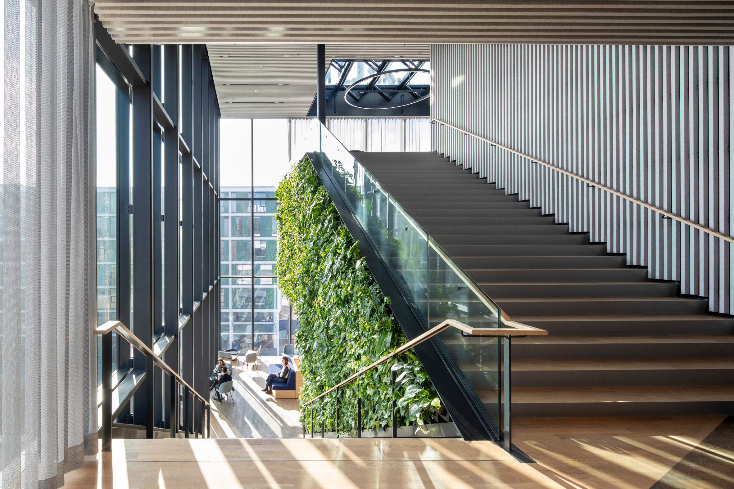 Large internal staircase with wood floors and green walls at the Matrix One building by MVRDV