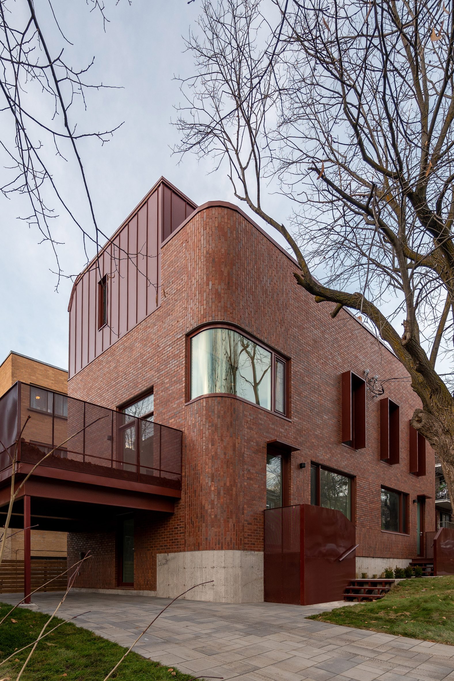 Red brick building with curved edges and metal top floor