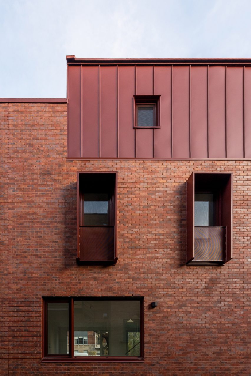 Edificio in mattoni rossi con tetto in metallo e schermi per la privacy in metallo
