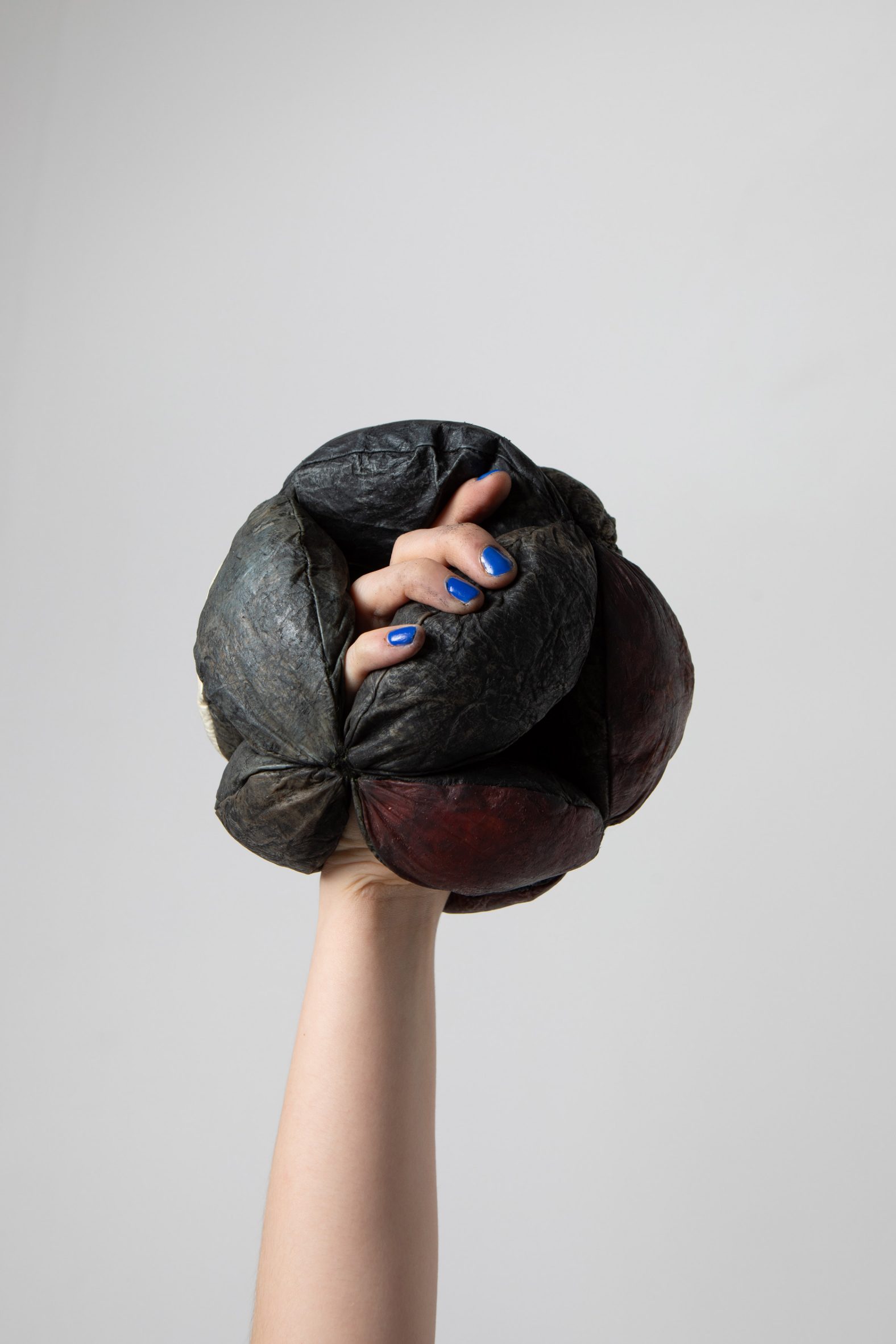 Hand and forearm with hand encased in fabric sphere
