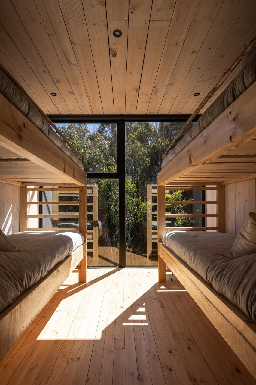 Dual bunk bed room with glass window looking out to the trees