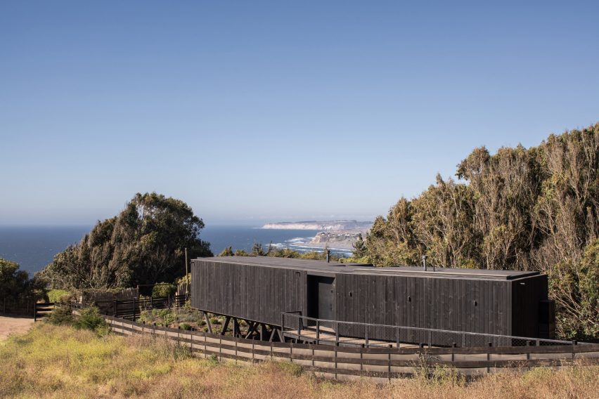 Blackened wood clad house with views of Chile's coastline behind