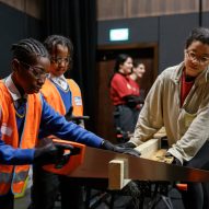 Children and volunteers sawing wood for the Let's Build Brixton House project
