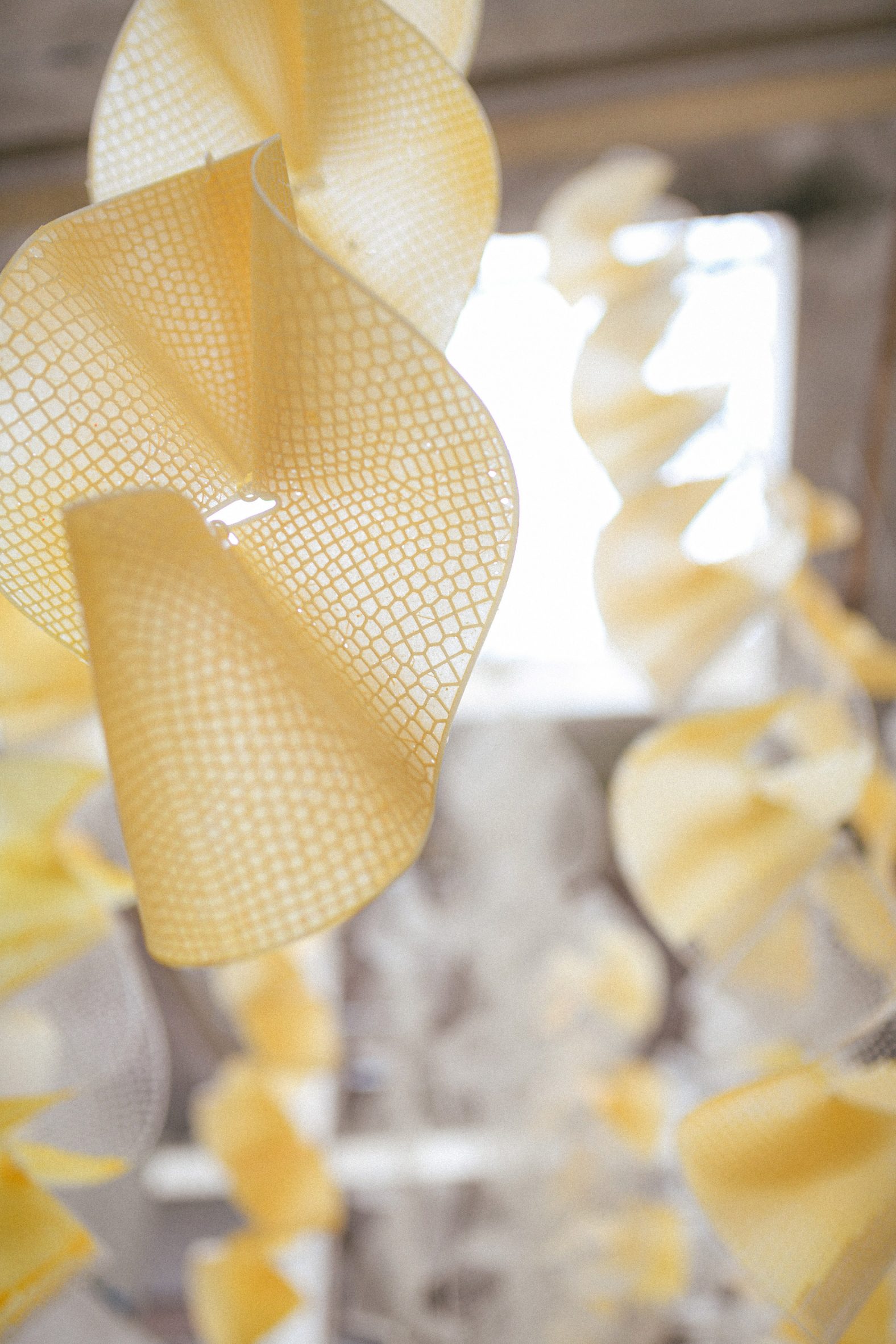 Close-up photo of the Sensbiom installation in its yellow state, showing the lattice structure that underlies the ribbons