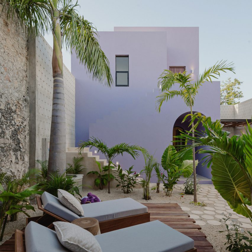 Purple two-storey cuboid house with sun lounges and palm trees