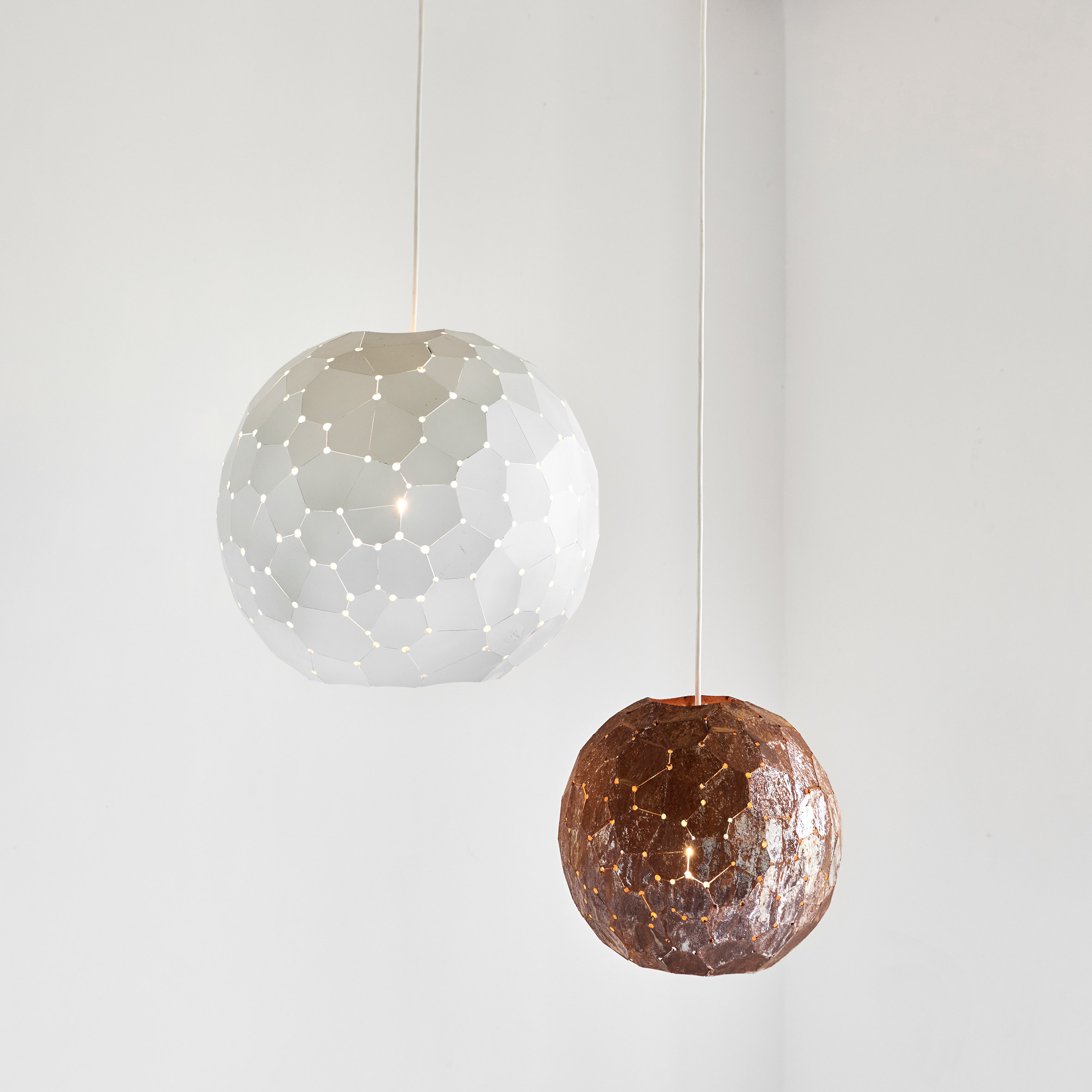 Spherical lamp shades in front of white wall