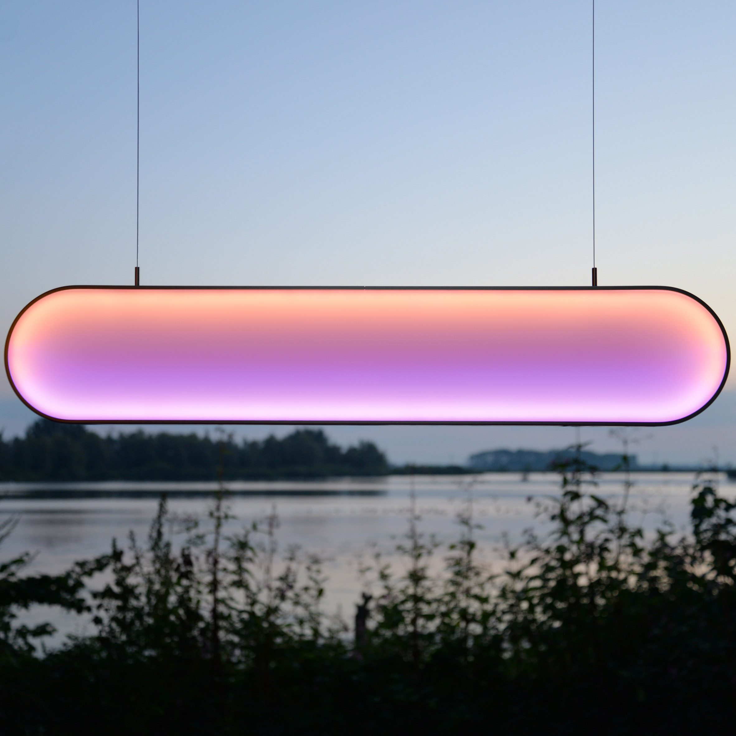 Pink and orange light hanging in front of lake view