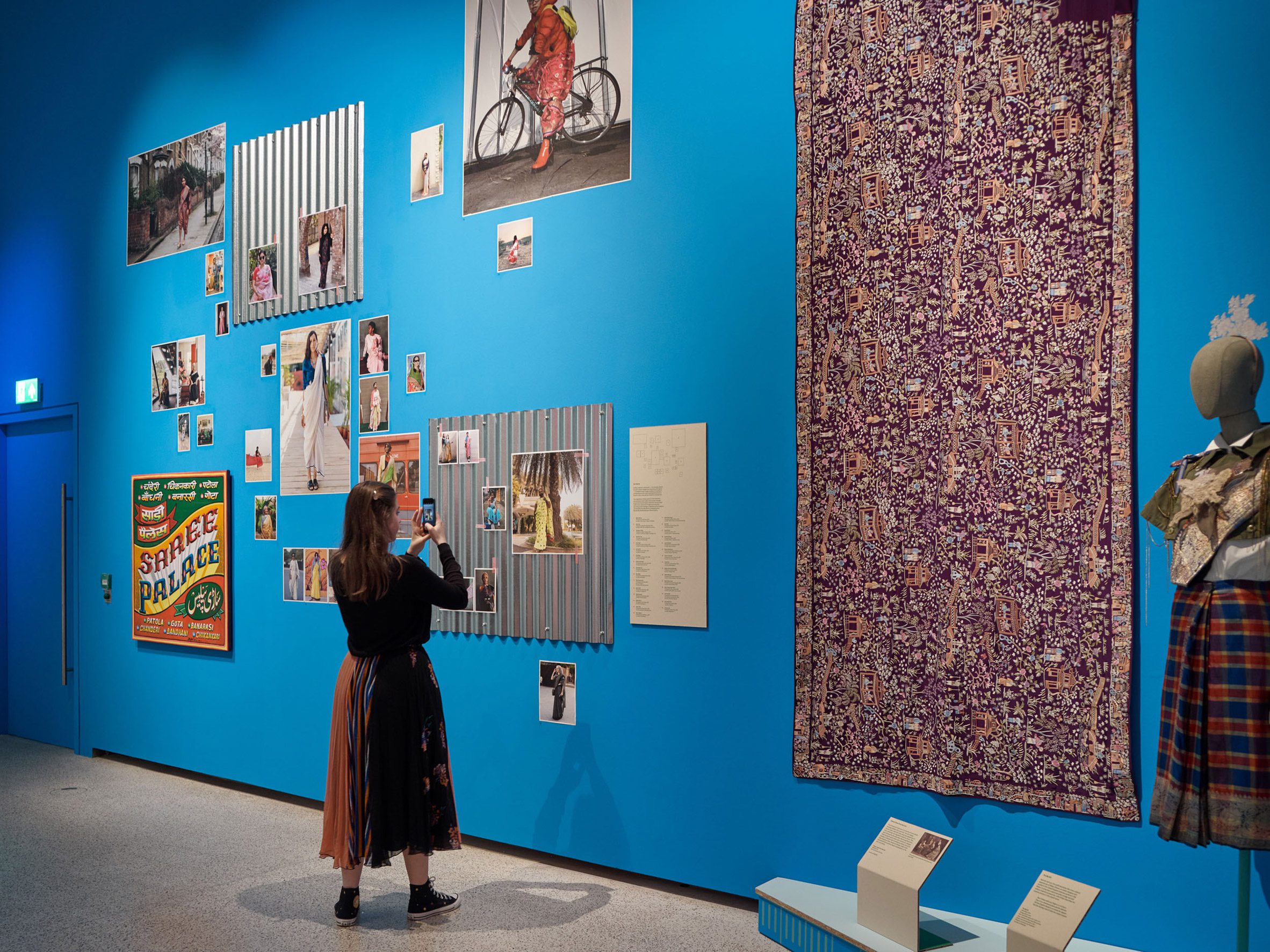 Blue wall with photographs of women wearing saris