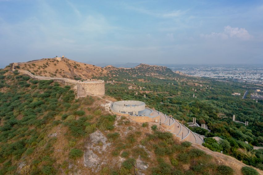 A hilltop with a fort wall and circular concrete structure