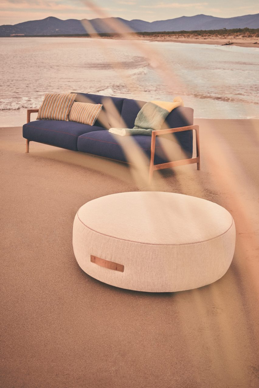 White pouf and navy sofa situated on beach