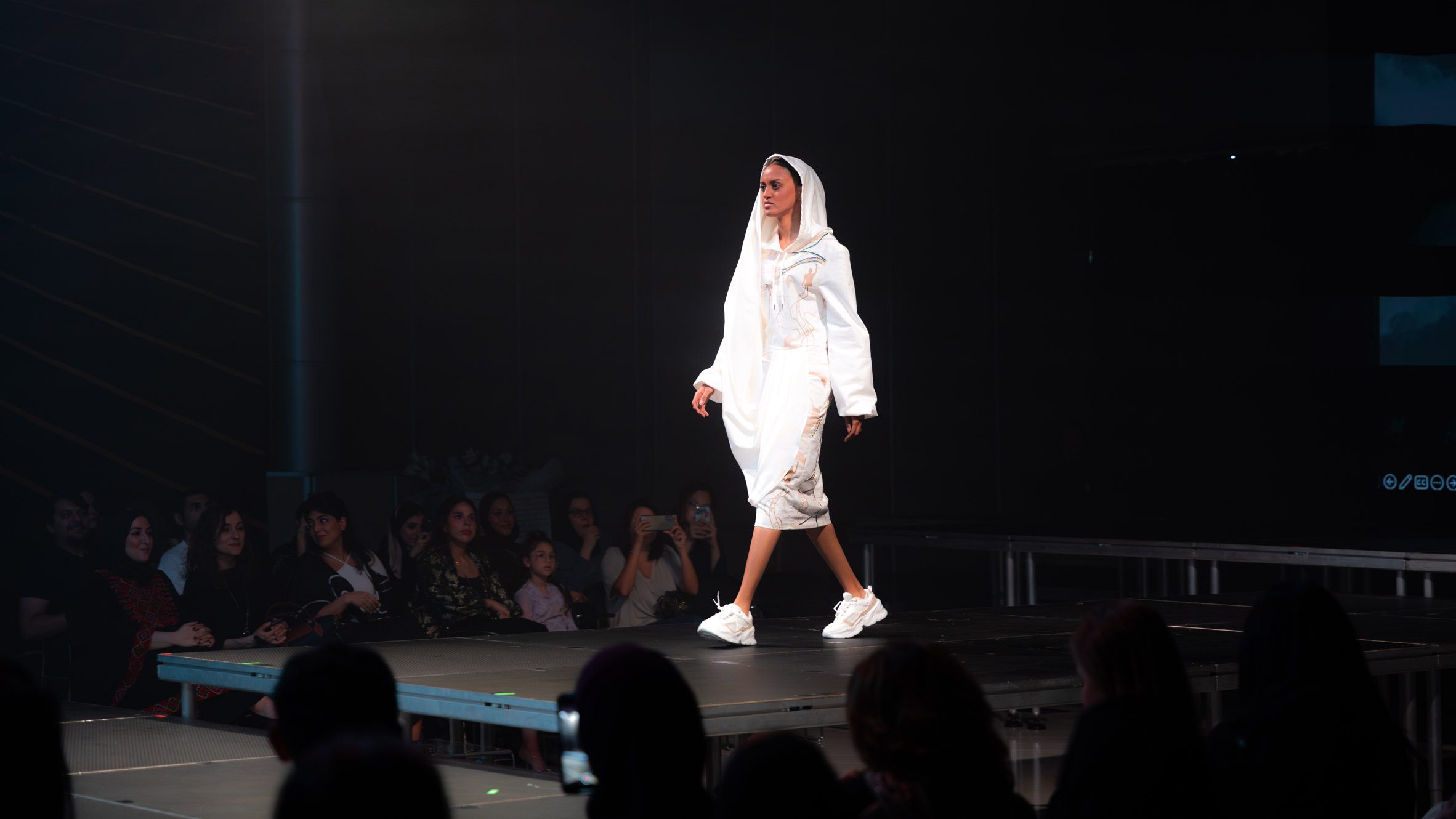 Model on runway wearing white garment 