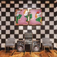 Checkerboard wall behind a stereo and two chairs