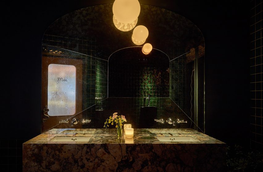 Темная мужская ванная комната с зеленой плиткой и мраморным туалетным столиком