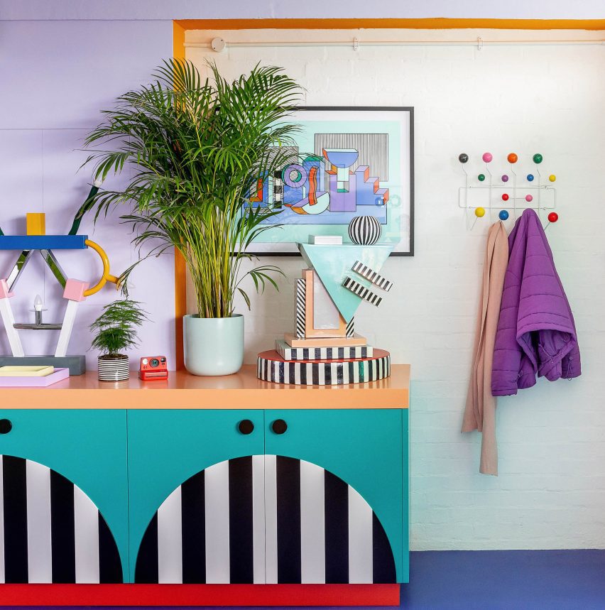 Foto de detalles en un colorido espacio de oficina con gabinetes audaces, pisos y plantas de color azul brillante y adornos coloridos en exhibición