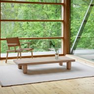 Wooden table in living space with window looking out onto trees