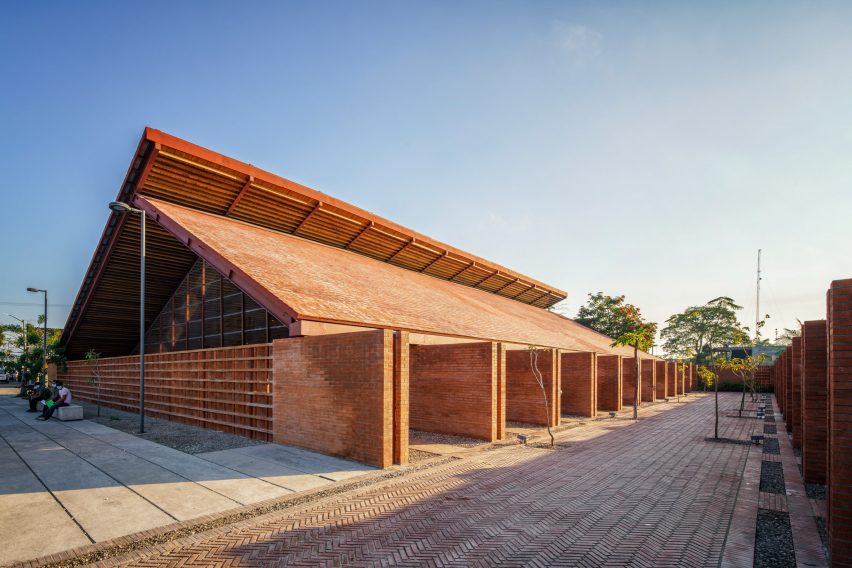 Exterior de la escuela Casa de Música con paredes de ladrillo extendidas y techos de madera en voladizo