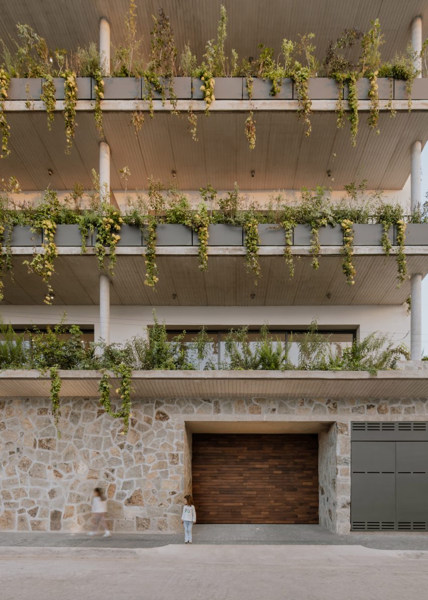 Apartment building in Mexico with stone lower walls and planted balconies