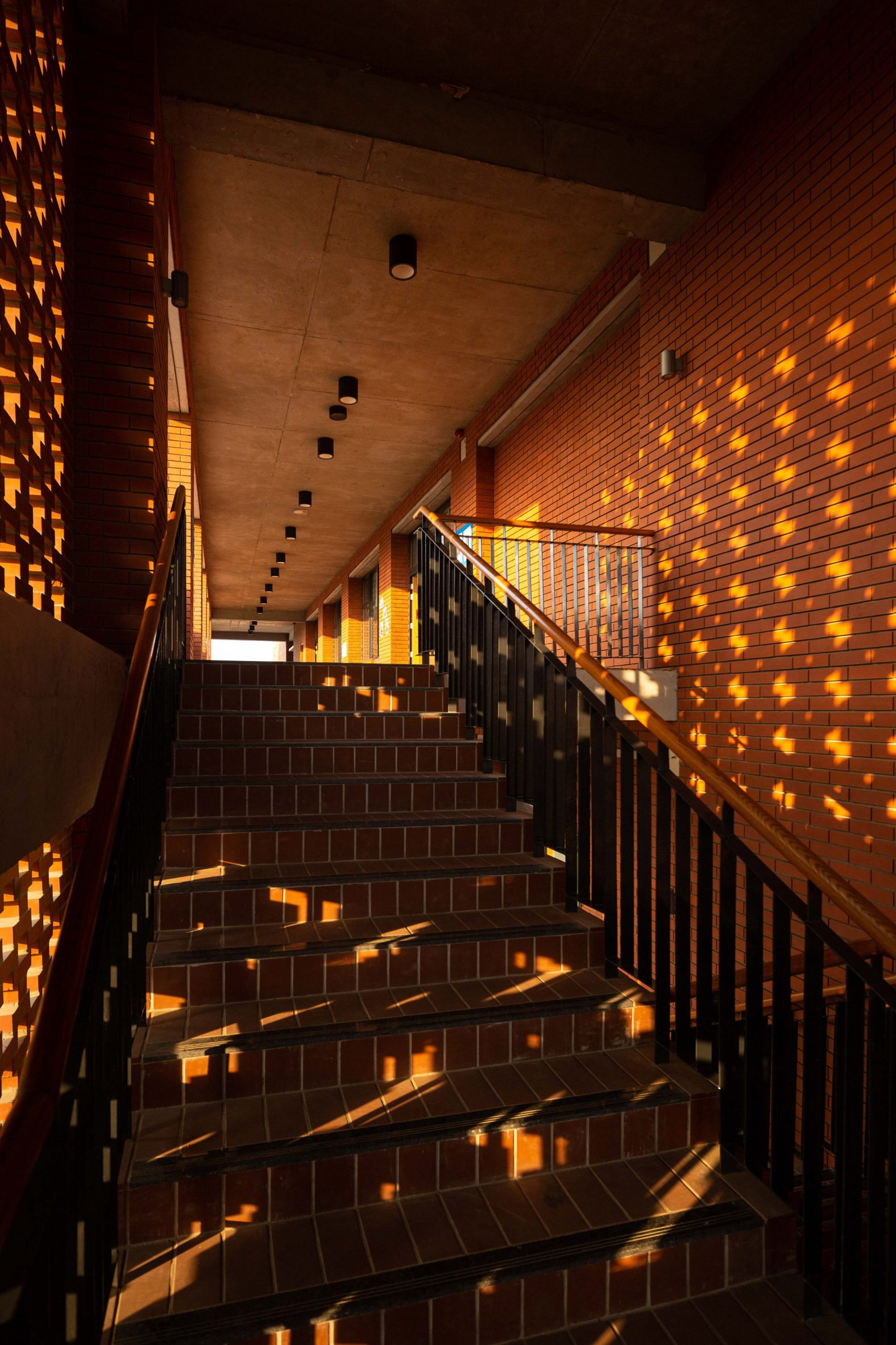Hallway illuminated by perforated brick screens