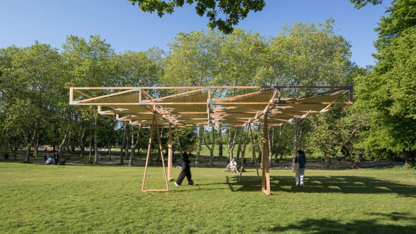 Person walking under the Craft Not Carbon timber pavilion in Crystal Palace Park