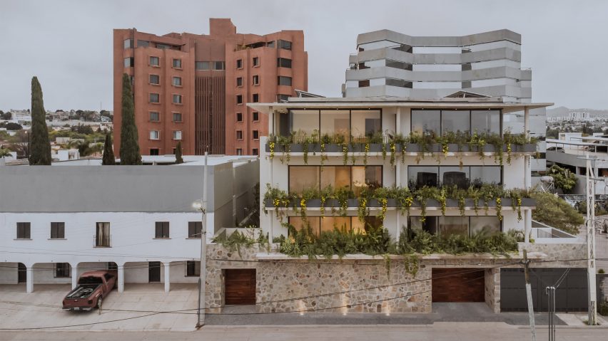 An apartment in Mexico with stone walls and plant-filled balconies