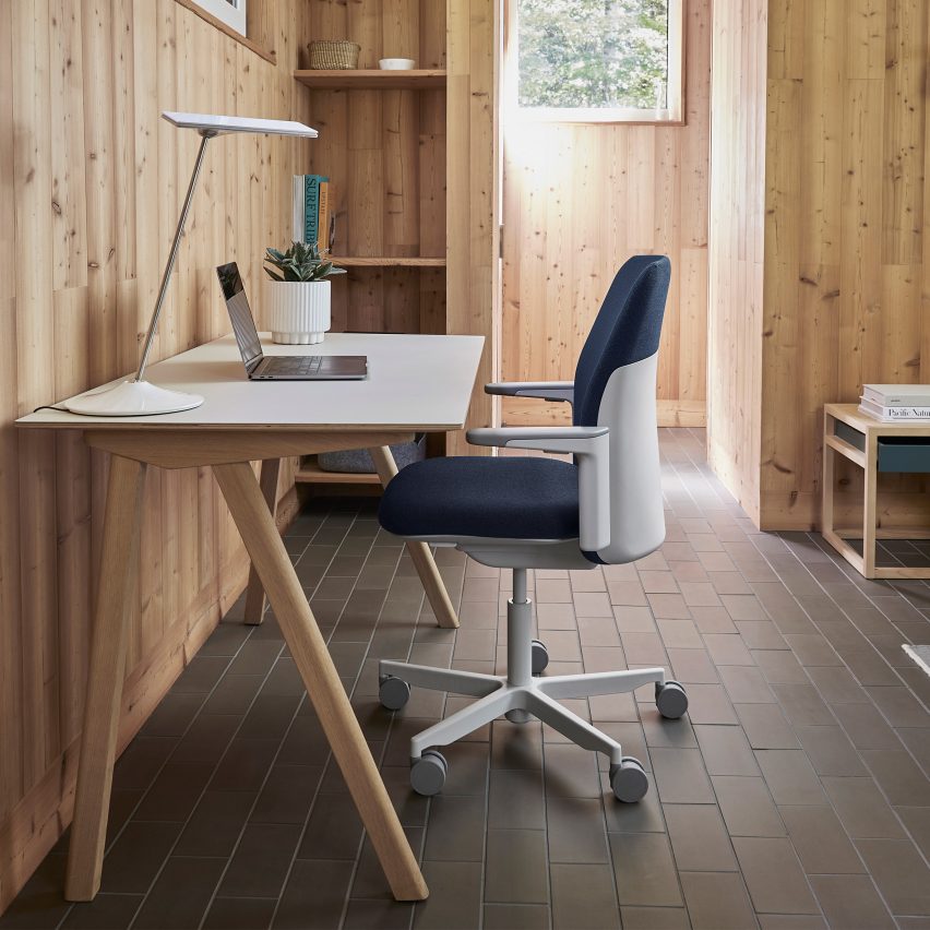 Blue upholstered Path office chair by Humanscale in a timber-clad interior at a wooden desk