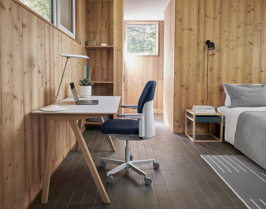 Silla de oficina Path tapizada en azul de Humanscale en un interior revestido de madera en un escritorio de madera