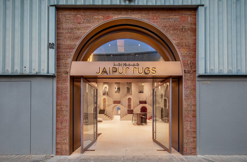 Photo of the outside of Jaipur Rugs Dubai showroom showing a brick entrance with rose gold signage built into a warehouse 