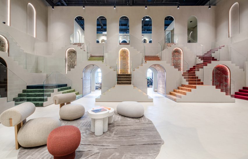 Photo of an open-plan showroom with repeated arches and sets of colourful carpeted stairs